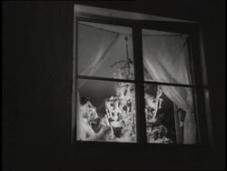 A father holds his toddler son while lighting a sparkler on a Christmas tree. News Clip