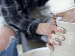 Midsection of woman throwing clay on potters wheel Stock Footage