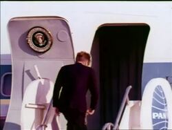 1963 President John Kennedy walks up stairs + stops in doorway of Air Force One to wave / Berlin Stock Footage