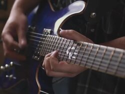 Handheld A musician strums his guitar. Stock Footage