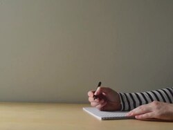 Woman writing in textbook Stock Footage