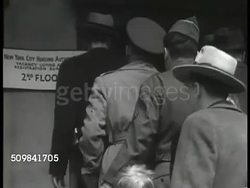 1946: NEW YORK CITY: EXT Housing Authority building w/ people walking sidewalk, elevated train BG. People in line on Housing Authority steps. INT Housing Authority office w/ people filling out forms, CU Registration form, people standing in line. Instructional Video