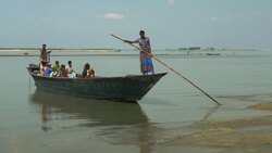 A traditional wooden passenger and goods boat in Northern Bangladesh prepares to cross the calm wide river delta  Stock Footage