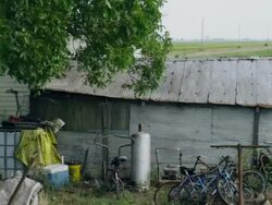 Drive by old run-down rural building house with junk in the yard Stock Footage