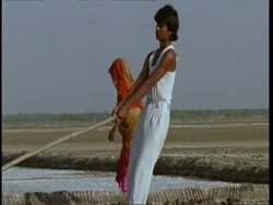 MS Gujarat, Indian woman turning soil with foot, man moves through foreground with hoe, Gujarat, India Stock Footage