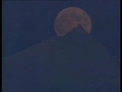 MS large pink full moon moving behind snow covered mountain peak, Arctic circle Stock Footage