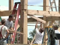 MS ZO Carpenter using large mallet while framing an energy efficient post   Stock Footage