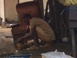 MS Shot of man washing his face hands and legs outside / Conakry, Guinea Stock Footage