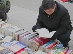 MS Man reading second hand book at market / xi'an, shaanxi, china Stock Footage