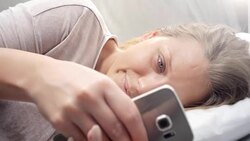 People waking up - Young Woman Texting in Bed Stock Footage