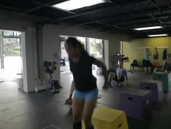 Camera tracks with Jonice as she performs series of box jumps in warm-up. Silhouette. Stock Footage