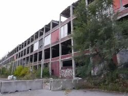 Exterior dolly view of abandoned auto assembly plant Stock Footage