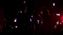 Crowd raising arms at concert with person sitting on shoulders Stock Footage