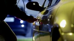 Man stealing a car by breaking the door lock Stock Footage