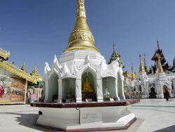 MS Shot of local people walking in front of white temple in shwedagon pagoda / Yangon, Yangon Division, Myanmar Stock Footage