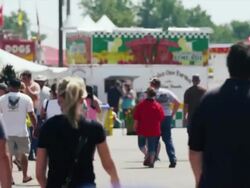 Concession stands at a crowded State Fair; people walk by camera. Stock Footage