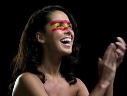 Woman with red and yellow face paint clapping Stock Footage