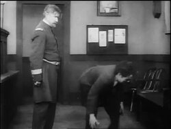 B/W 1917 policeman hitting Charlie Chaplin / Chaplin hitting back then shaking hands with policeman Stock Footage