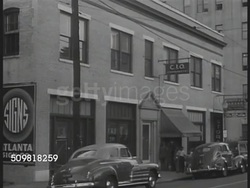 1944: MANUFACTURING: African-American male working on machine, female working w/ Caucasian male. EXT C.I.O. headquarters. C.I.O. Meeting. Poster ' UAW-CIO ...equal pay for equal work' Caucasian Union official speaking to African-American audience. Instructional Video