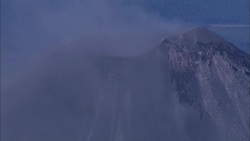 A volcanic crater spews ash and smoke. Stock Footage