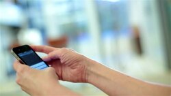 Businesswoman searches the web with smart-phone Stock Footage