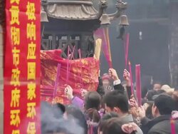 MS Pilgrims raising joss sticks to touch tintinnabulum of cense burner pray for good luck during Chinese Lunar New Year at Taoist temple / xi'an, shaanxi, china Stock Footage
