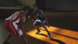 A basketball player dribbles around his defender in a one-on-one game. Stock Footage