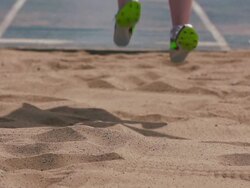 Track and field athlete in slow motion doing long jump Stock Footage