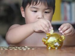 Boy putting money in piggy bank Stock Footage