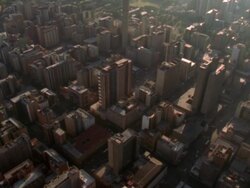 Aerial shot over the buildings and streets of the Central Business District of Johannesburg with the Hillbrow Tower towering above Stock Footage