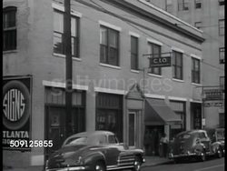 1944: MANUFACTURING: African-American male working on machine, female working w/ Caucasian male. EXT C.I.O. headquarters. C.I.O. Meeting. Poster ' UAW-CIO ...equal pay for equal work' Caucasian Union official speaking to African-American audience. Instructional Video