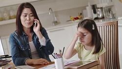 Mom entrepreneur talking on phone and looking after daughter Stock Footage