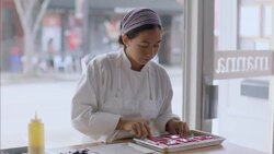 Pastry chef scoops gourmet cake from tray and places delicately on dessert dish in restaurant window Stock Footage