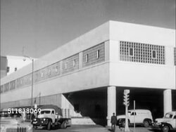 1950: DENVER, COLORADO: NEWSPAPER: WS The Denver Post building w/ delivery trucks parked curbside. PAN Building. INT The Denver Post w/ Publisher & Editor Palmer Hoyt sitting on desk, taking paper message from man. Instructional Video