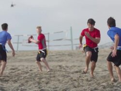 A group of guys playing flag football on the beach. - Super Slow Motion - filmed at 240 fps Stock Footage