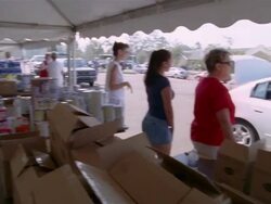 September 2005 Volunteers at Hurricane Katrina relief center directing cars and packing boxes of supplies / woman holding little girl / Mississippi Stock Footage
