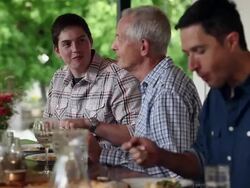 MS family dining at table outdoors on front porch of home Stock Footage