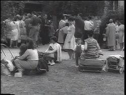B/W 1961 crowd of East German refugees standing + sitting on ground / beginning of Berlin Wall Stock Footage