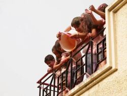 Senior man playing holi festival with his grandchildren at roof top  Stock Footage