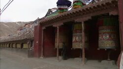 A man spins a prayer wheel in a Tibetan temple. Stock Footage