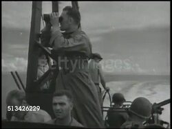 1943: NEW BRITAIN CAMPAIGN:  VS U.S. Army 112th Cavalry Regiment in amphibious landing crafts approaching New Britain island, firing anti-aircraft machine guns at Japanese fighter airplanes flying overhead, fighter plane burning, going down. WWII Instructional Video