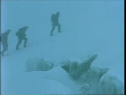 MS zooming out to WA, Silhouetted people slowly climbing glacier in fog, Rwenzori Mountains, Uganda Stock Footage