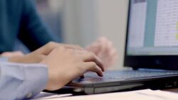 Hip young businessman and older businesswoman confer, update spreadsheet on laptop-computer in corporate boardroom (detail) Stock Footage
