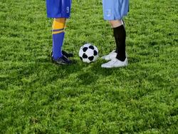 MS TU professional soccer players from opposing teams shaking hands over ball in center of field at night Stock Footage
