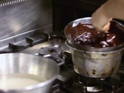 CU Shot of pastry chef mixing chocolate glaze on cooker / Rome, Lazio, Italy Stock Footage