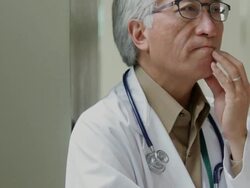 Serious Asian doctor thinking with hand on chin Stock Footage