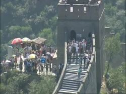 Zoom out from tourists milling around tower on Great Wall of China, high angle, Badaling, China Stock Footage