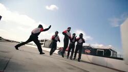 Stock car driver speeds out of pit-road, pit-crew celebrates job well done Stock Footage