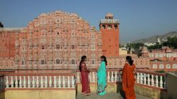 Three women in colorful saris visit on a balcony near Palace of the Winds in Jaipur, India. Stock Footage