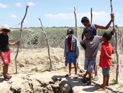 MS PAN Shot of Kids watching man digging to reach water / Pilao Arcado, Bahia, Brazil Stock Footage